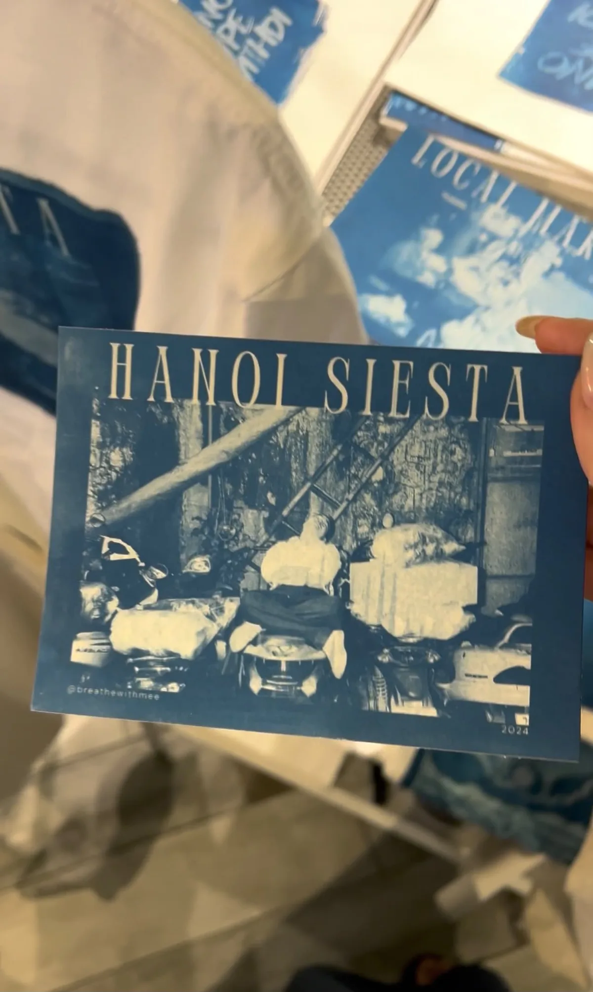 Hand holding a cyanotype postcard titled Hanoi Siesta